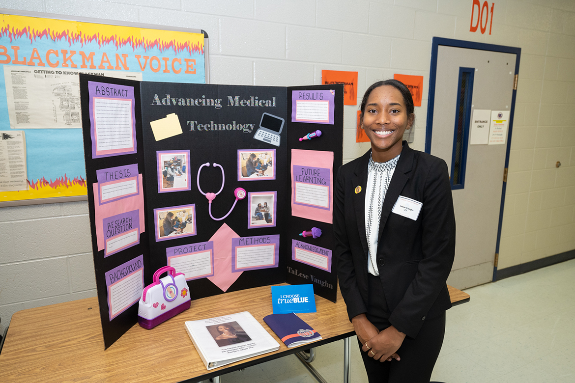 One of more than 50 Blackman High School seniors conducting research this fall, TaLese Vaughn stands with her project titled "Outdated Medical Technology Affecting the Patients," at the eighth annual Blackman Collegiate Academy Capstone Symposium Dec. 7 at the school. She is considering Middle Tennessee State University as one of her college choices and plans to major in premedicine. (MTSU photo by James Cessna)
