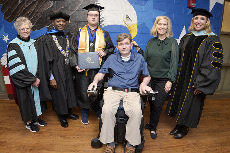 At the patriotic mural outside MTSU's Charlie and Hazel Daniels Veterans and Military Family Center, Dr. Deb Sells, left, vice president of student affairs, President Sidney A. McPhee and Daniels Center Director Hilary Miller, right, congratulate fall 2022 graduate Brad Trotter, center left, and his parents, Chaz and Wendy Trotter after a special commencement ceremony Wednesday, Dec. 7. Brad Trotter, a political science major, will graduate at 2 p.m. Saturday, Dec. 10, with his class in the official fall 2022 commencement ceremony in Murphy Center. Chaz Trotter, a U.S. Navy veteran, has Lou Gehrig’s disease and will watch the event on the university’s True Blue TV, and Wendy Trotter will attend with more family members. (MTSU photo by Andy Heidt)