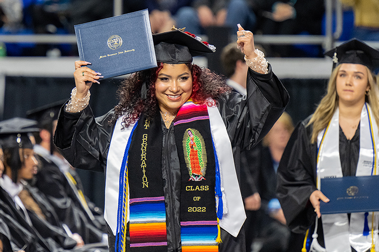 A member of MTSU's fall Class of 2022 smiles as she carries her new degree back to her seat in Hale/Earle Arena inside Murphy Center during the university's Dec. 10 commencement ceremonies. MTSU presented 1,698 students with their degrees — 1,345 undergraduates and 353 graduate students — to mark the first graduation of its 112th academic year. (MTSU photo by Cat Curtis Murphy)
