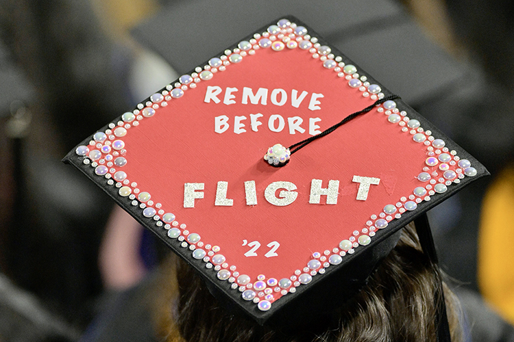 A member of MTSU's fall Class of 2022 celebrates their graduation with a personalized mortarboard reading "REMOVE BEFORE FLIGHT, '22" in Hale/Earle Arena inside Murphy Center during the university's Dec. 10 commencement ceremonies. MTSU presented 1,698 students with their degrees — 1,345 undergraduates and 353 graduate students — to mark the first graduation of its 112th academic year. (MTSU photo by Andy Heidt)
