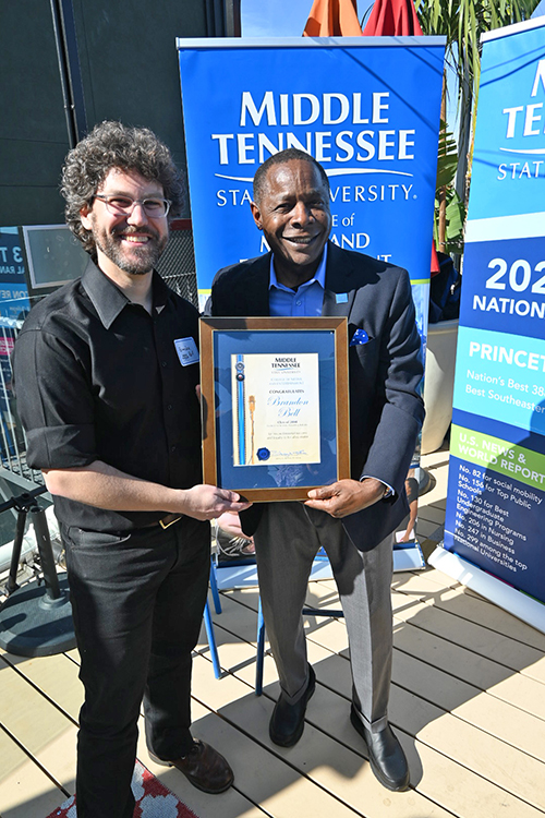 Middle Tennessee State University President Sidney A. McPhee, right, presents recording industry alumnus and Grammy winning audio engineer Brandon Bell (’04) with a special certificate in honor of his career success thus far at a university-hosted pre-Grammy Awards event held Saturday, Feb. 4, on the rooftop of the Mama Shelter hotel near Hollywood. Bell is nominated for multiple Grammys for his engineering work this year. (MTSU photo by Andrew Oppmann)