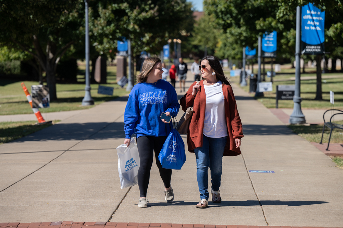 Wearing a Middle Tennessee State University sweatshirt, a prospective student strolls down the walkway on campus with her mother when they attended the first fall True Blue Preview event in October 2022. MTSU Admissions offers two preview events — Feb. 11 and March 26 — for potential students to capture a glimpse of the campus atmosphere. (MTSU file photo by James Cessna)