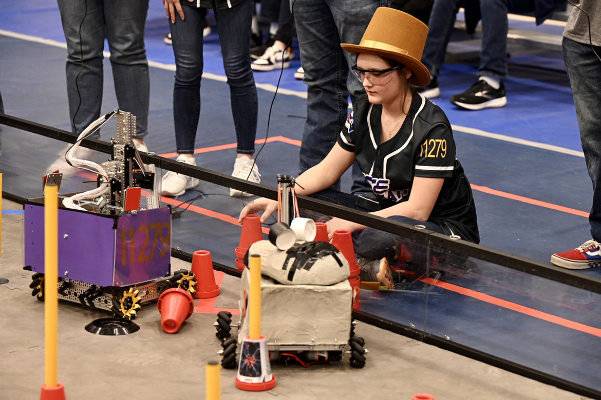 Wearing a Willy Wonka & the Chocolate Factory hat, a team member for the Pure Imagination team from Granada, Miss., watches as their robot, “Grandpa George,” maneuvers and picks up red cones during an early-round match at the TNFIRST First Tech Challenge Tennessee State Championship in robotics on Saturday, Feb. 18, at Middle Tennessee State University’s Alumni Memorial Gym. (MTSU photo by James Cessna)