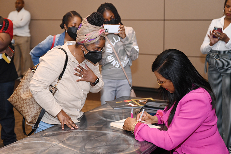 An audience member watches closely as author and educator Ilyasah Shabazz, right, signs a book for her after Shabazz's keynote address Monday, Feb. 27, in the Student Union’s ballroom to conclude Middle Tennessee State University’s 2023 Black History Month activities. (MTSU photo by James Cessna)