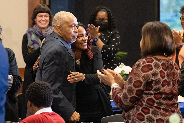 As family, friends and colleagues applaud, MTSU Health and Human Performance professor Chandra Russell Story, center, is hugged by her father, Eugene H. Russell III, after accepting the 2023 John Pleas Faculty Recognition Award during a special ceremony Tuesday, Feb. 21, at the Ingram Building’s MT Center. (MTSU photo by Cat Curtis Murphy)
