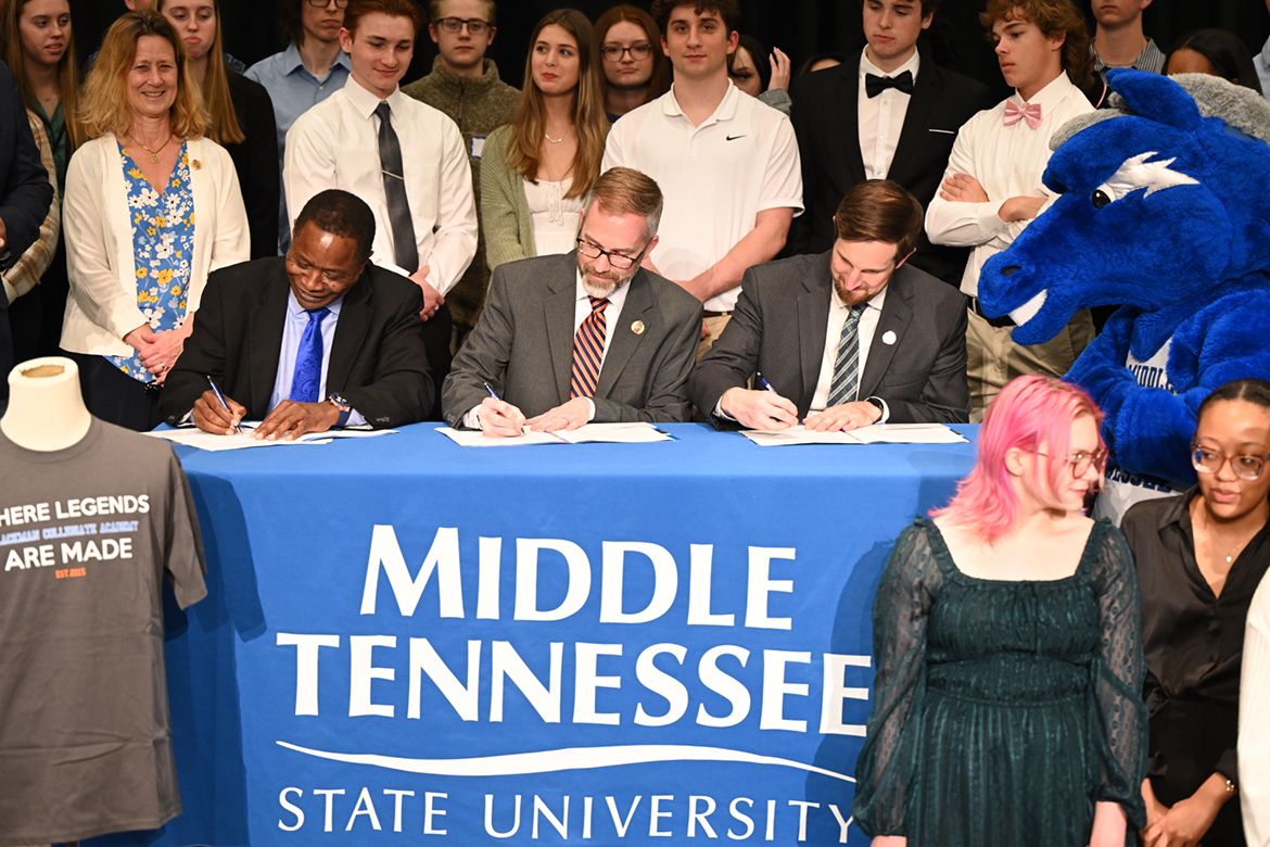 With about 80 Blackman High School students flanking them, MTSU President Sidney A. McPhee, Blackman Principal Justin Smith and Rutherford County Schools’ Director Jimmy Sullivan signed a renewal of the memorandum of understanding between the university and local high school.
The signing occurred Friday, March 24, in the MTSU Student Union Ballroom, as a universitywide Scholars Week event led by the Office of Research and Sponsored Programs — with 10 Blackman seniors participating — was about to wrap up. (MTSU photo by James Cessna)
