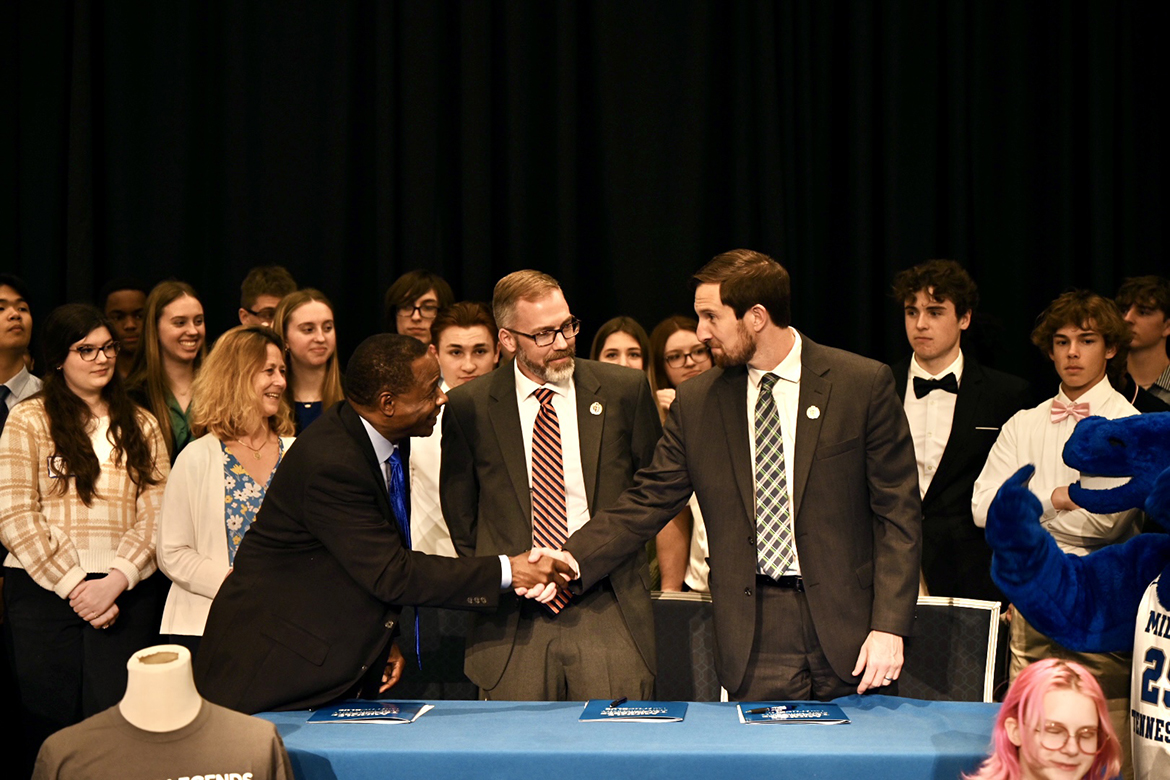 Middle Tennessee State University President Sidney A. McPhee, left, shakes hands with Rutherford County Schools Director Jimmy Sullivan, as Blackman High School Principal Justin Smith observes. They had just signed a renewal of a memorandum of understanding between MTSU and the Murfreesboro high school, one of the largest in Tennessee. The two academic partners are wrapping up the eighth year of the collegiate academy. (MTSU photo by James Cessna)