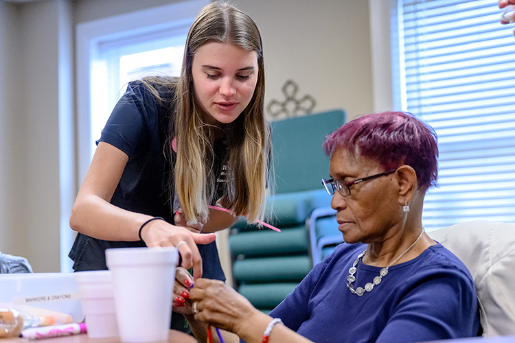 Insa Feldhusen, left, Middle Tennessee State University nursing student, helps a member of the local Mindful Care adult day program with a craft project as part of a new partnership between the nonprofit and School of Nursing students in the Health and Gerontology course on March 13, 2023, in Murfreesboro, Tenn. (MTSU photo by J. Intintoli)