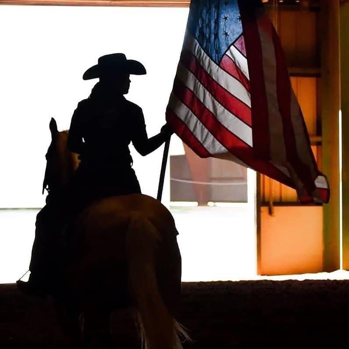 A member of one of the Middle Tennessee State University equestrian teams carries the U.S. flag into the Tennessee Livestock Center during the opening ceremony for the CERV Spring Spectacular Open Show in April 2022.. This year’s benefit horse show will be held from 8 a.m. to 5 p.m. Saturday, April 1, the MTSU’s Tennessee Livestock Center. (Submitted photo)