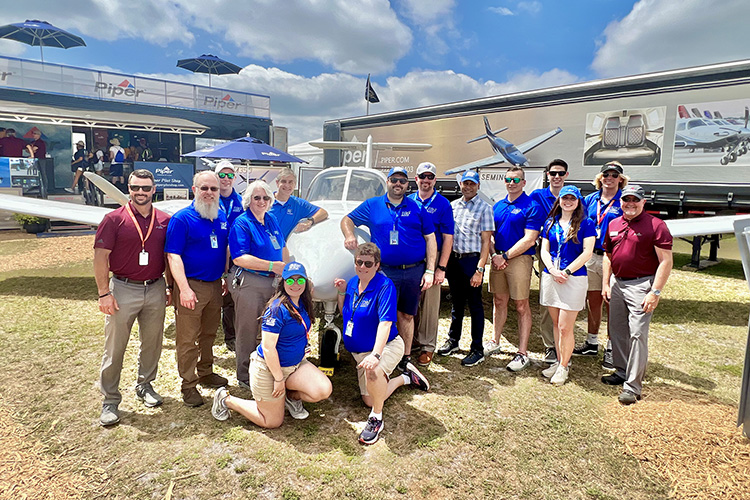 A delegation of MTSU Aerospace faculty, flight instructors and students and representatives for Piper Aircraft stand in front of one of the university’s new twin-engine Seminole aircraft on display Wednesday, March 29, at Sun ’n Fun Aerospace Expo in Lakeland, Fla. The Seminole is part of the Piper Aircraft display at the event and is one of two such aircraft MTSU purchased late last year to add to its training fleet. The MTSU Aerospace delegation visited the event to accept the first of eight new Diamond aircraft. (MTSU photo by Andrew Oppmann)