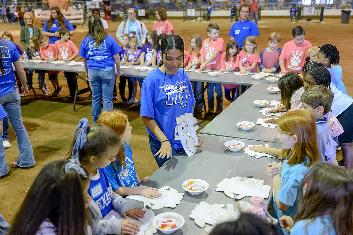 Nivea Gilchrist, 18, center, a Middle Tennessee State University freshman animal science major from Nashville, Tenn., helps youngsters attending the annual MTSU School of Agriculture Ag Education Spring Fling get started on craft sheet puppets with materials an agritourism class provided for them. Six different schools brought nearly 900 students by bus to the event, held in the Tennessee Livestock Center on campus. (MTSU photo by J. Intintoli)