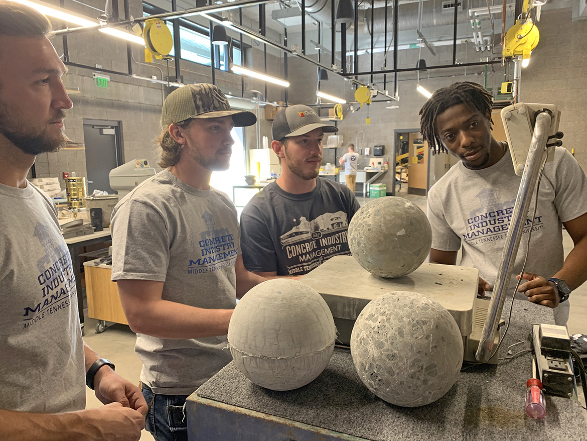 From left, Middle Tennessee State University Concrete Industry Management students Adam Currie of Brownsville, Tenn., Joe Bell of Murfreesboro, Clay Karsner of Danville, Ky., and Tyler Dixon of Murfreesboro and formerly from Brandon, Miss., check the weight of a concrete bowling ball they created in their upper division class recently in the School of Concrete and Construction Management Building CIM laboratory. Bell and Karsner will be among six students heading to San Francisco, Calif., Saturday, April 1, to compete in the international American Concrete Institute’s Student Fiber-Reinforced Concrete Bowling Ball Competition on April 2. (MTSU photo by Randy Weiler)