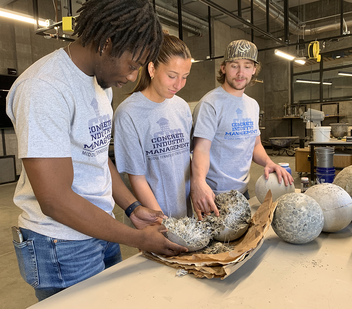 From left, Middle Tennessee State University Concrete Industry Management students  Tyler Dixon, Ashley Gates and Joe Bell — all from Murfreesboro — check the fiber content of a concrete bowling ball they made and tested for the upcoming international competition a group of six students will compete in Sunday, April 2, in San Francisco, Calif., during the ACI Convention. The upper division class made the balls in the new CIM laboratory in the 54,000-square-foot School of Concrete and Construction Management Building, which opened in October. (MTSU photo by Randy Weiler)