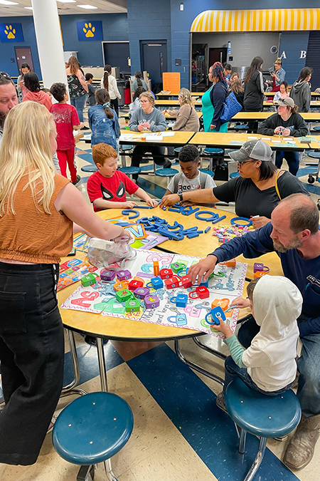 Families work together on activities at a math and literacy night event at John Pittard Elementary in Murfreesboro, Tenn., on March 23, 2023, co-organized by faculty and students from Middle Tennessee State University’s College of Education. (MTSU photo courtesy of Katie Schrodt)