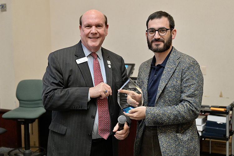 State Farm Outstanding Faculty Award recipient Ennio Piano, right, assistant professor, Political Economy Research Institute and MTSU Department of Economics and Finance, accepts his award from Jones College of Business Dean David Urban during an awards ceremony April 14 in the State Farm Lecture Hall inside the Business and Aerospace Building. (MTSU photo by Andy Heidt)