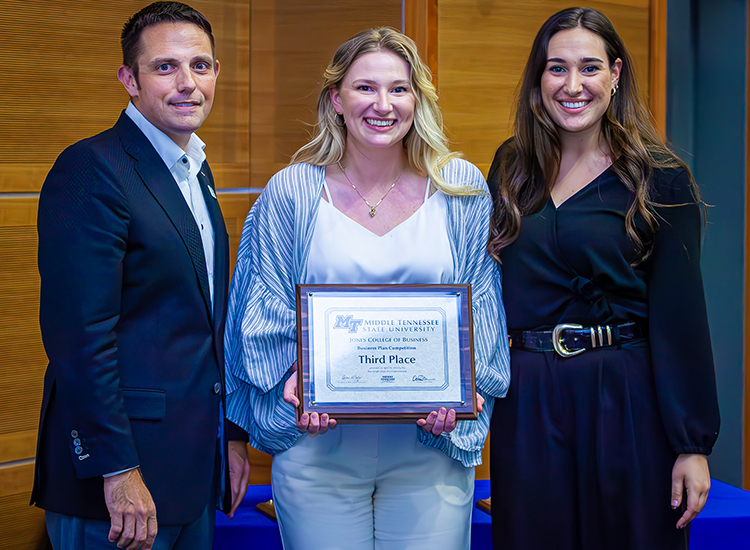 From right, fall 2022 MTSU graduate Jamie George, of Portland, Tenn., and her friend and business partner Haley Harris of Phoenix, Ariz., accept the third place plaque from Joshua Aaron, chairholder of the Wright Chair of Entrepreneurship and competition organizer, at the 2023 Business Plan Competition Finals held April 26 in the Student Union Parliamentary Room at Middle Tennessee State University. The duo won $5,000 for their plan for Like a Virgin Sober Bar. (MTSU photo by Tom Beckwith)