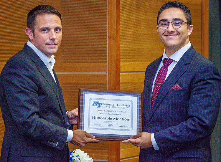 Spring 2023 graduate Samer Kattih, a political science major from Murfreesboro, Tenn., accepts his honorable mention plaque from Joshua Aaron, chairholder of the Wright Chair of Entrepreneurship and competition organizer, at the 2023 Business Plan Competition Finals held April 26 in the Student Union Parliamentary Room at Middle Tennessee State University. As a finalist, Kattih earned a $2,000 prize for his plan for the Kattih Syndications real estate investment firm. (MTSU photo by Tom Beckwith)