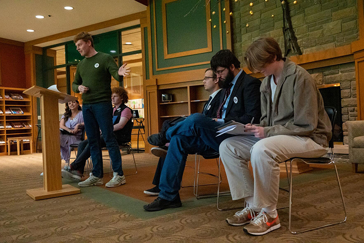 Irish debate student Gavin Dowd speaks during a March 15, 2023, debate at the Brentwood Library between the winners of Ireland's National Debate Championship and MTSU's award-winning Blue Raider Debate Team. Seated behind him, from left, are Irish teammates Ailbhe Noonan and Oliver McKenna. Seated at right, from left, are MTSU Debate Team members Graham Christophel, Derek Dismukes and L.B. Boardwine. (Photo by Matt Masters/Williamson Source)