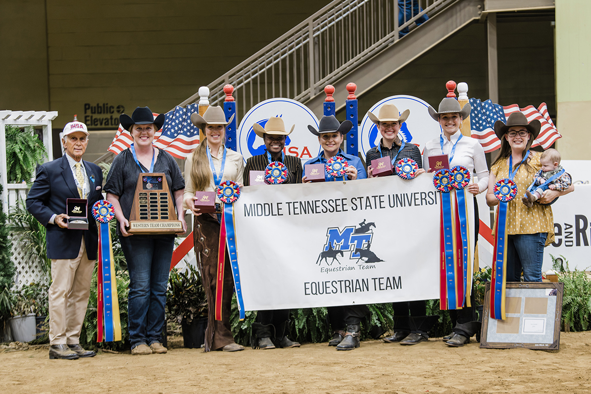 Team Champions trophy, Middle Tennessee State University equestrian team members include, from left, coach Ariel Higgins, Audrey Ferrie, Sadio Barnes, Mackenzie Latimer, Jordan Martin, Jessie Kauffman and assistant coach Andrea Rego, holding Levi Rego, during closing ceremonies at the event at Kentucky Horse Park in Lexington, Ky. (Photo by EQ Media)