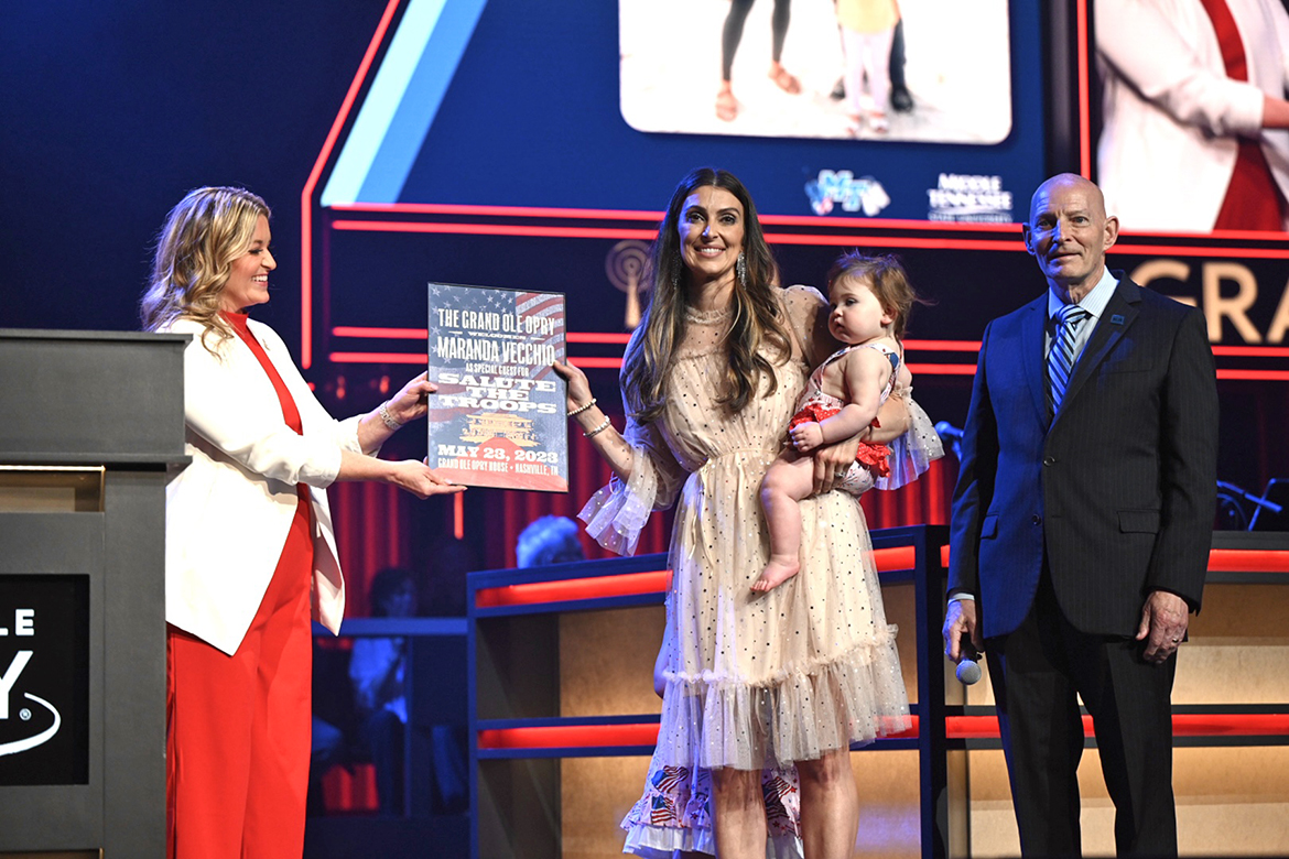 Opry announcer Kelly Sutton, left, presents Air Force veteran Maranda Vecchio, a graduate student in the MTSU physician assistant program, with special recognition during the Grand Ole Opry Salutes the Troops event on Tuesday, May 23, in Nashville, Tenn. Retired Army Lt. Gen. Keith Huber, MTSU’s senior adviser for veterans and leadership initiatives, served as an Opry guest announcer. (MTSU photo by James Cessna)