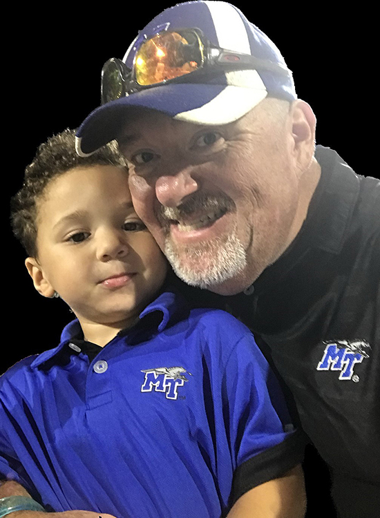 In this undated photo, MTSU alumnus and EMT Scott Storey (Class of 2017) of Mt. Pleasant, Tenn., right, and his youngest son, Ben, show off their Blue Raider gear in support of MTSU football. Storey, now 53, earned his bachelor’s degree in professional studies through MTSU Online. (Submitted photo)