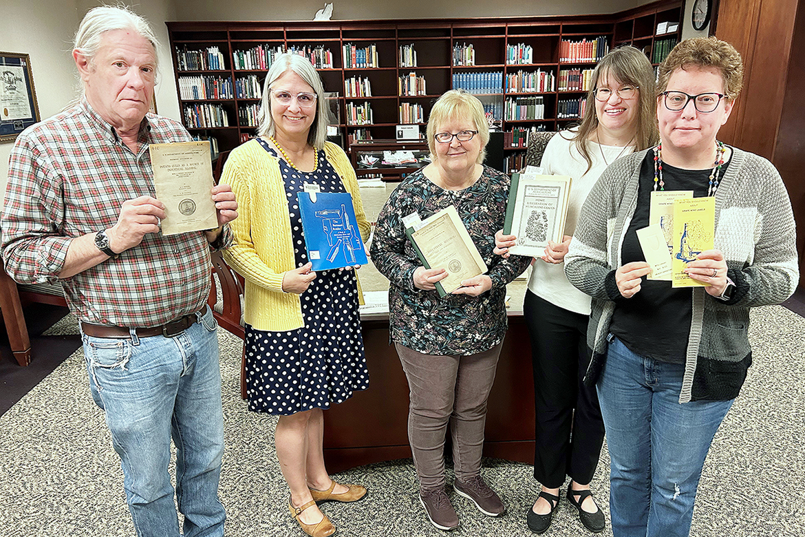 MTSU James E. Walker Library Special Collections staff holding items in the Distilling, Fermenting and Brewing Collection are, from left, Alan Boehm, head of Special Collections; Susan Martin, chair of collection development and management; Susan Hanson, Special Collections cataloguing; Beverly Geckle, continuing resources librarian and Federal Depository Library coordinator; and Toni Butlet Click, continuing resources coordinator and federal documents assistant. (Nancy DeGennaro/MTSU)