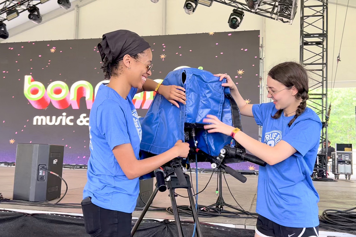 MTSU College of Media and Entertainment students Kayla Bradshaw, left, and Olivia Doyle prepare a camera near Bonnaroo’s “This” stage as part of the university’s assignment to handle live TV production for streaming service Hulu of 25 concerts during the four-day festival. (MTSU Photo by Andrew Oppmann)