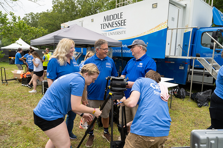 MTSU media arts associate professor Bob Gordon, back row, right, briefs University Provost Mark Byrnes and Media and Entertainment Dean Beverly Keel on the live television production work being done by students at this year’s Bonnaroo Music and Arts Festival. MTSU’s almost $2 million Mobile Production Lab, known affectionally as “The Truck,” will be used to record 25 performances at this year’s four-day event. (MTSU Photo by James Cessna)
