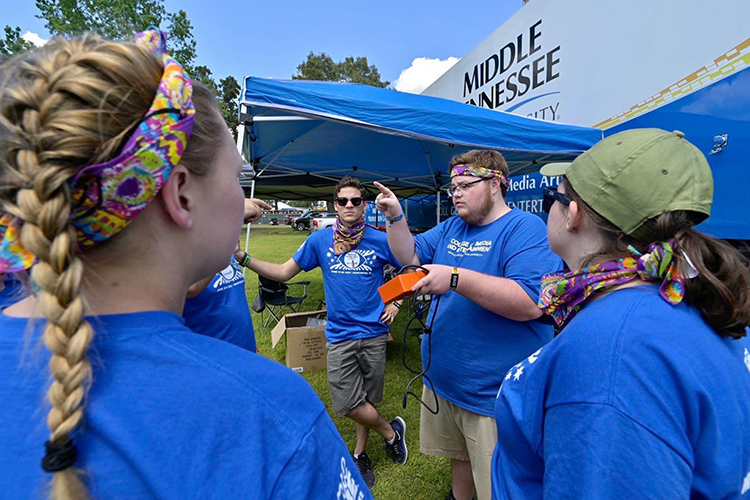Pictured in this undated file photo from a previous Bonnaroo Music and Arts Festival in Manchester, Tenn., Middle Tennessee State University alumnus Ryan Tyler (Class of 2021), center right, and alumnus Jo Litzenberger (Class of 2020), center left, coordinate with other MTSU students working the annual festival. Tyler says the real-world experience working at Bonnaroo as a student was instrumental in shaping his career path. Tyler is a production associate for the Trinity Broadcasting Network. (Submitted photo)