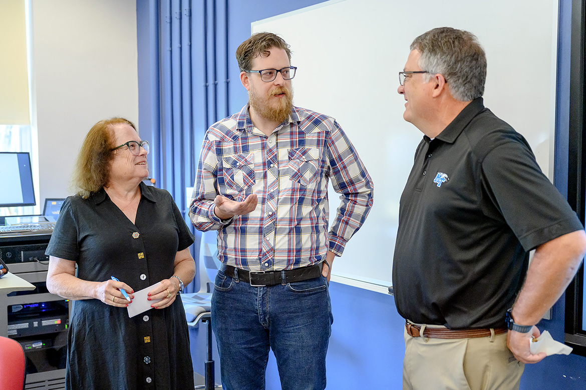 Middle Tennessee State University Department of Mathematical Sciences professor Mary Martin, left, and Provost Mark Byrnes, right, visit with Canadian college adjunct math professor Micah McCurdy, creator and owner of hockeyviz.com, who has turned a sports data analytics hobby into a money-making proposition. McCurdy spoke to about 20 MTSU students, faculty and administrators in Kirksey Old Main on Wednesday, June 28. (MTSU photo by J. Intintoli)