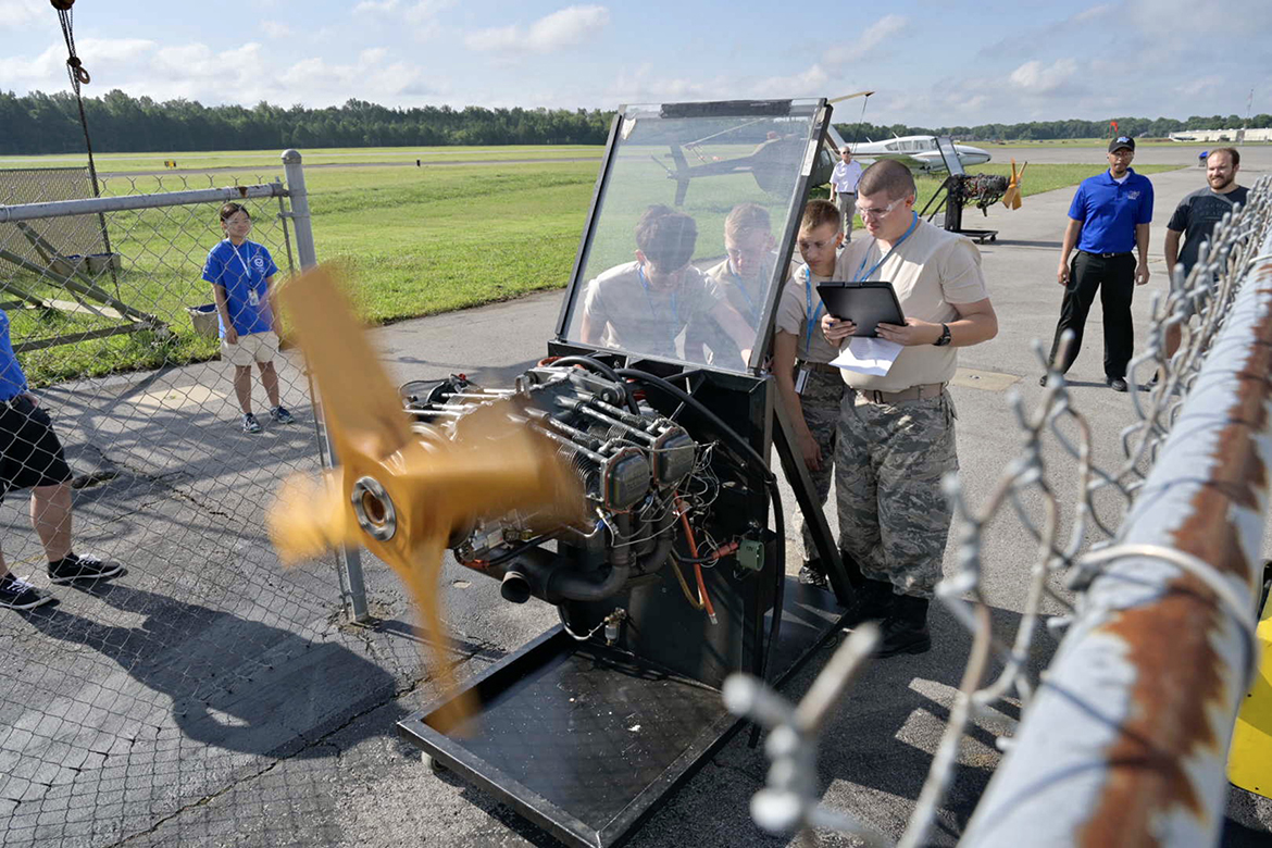 As Middle Tennessee State University Department of Aerospace staff and students observe in the background, four Civil Air Patrol cadets practice on an engine stand Monday, July 10, at Murfreesboro Airport as part of their activities during the weeklong National Cadet Engineering Technology Academy, also known as E-Tech. MTSU again hosted the academy to expose cadets from all over the nation to a variety of science and engineering fields. (MTSU photo by Andy Heidt)