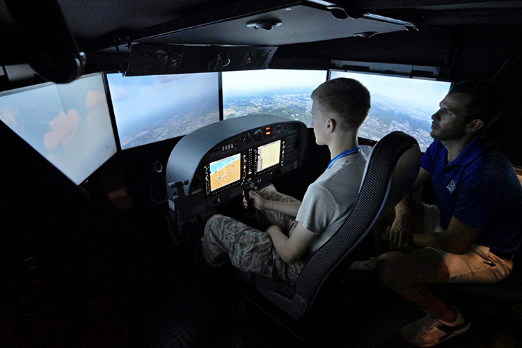 As certified flight instructor Trey Welch, right, looks on, a Civil Air Patrol cadet attending the weeklong National Cadet Engineering Technology Academy, also known as E-Tech, practices on a Department of Aerospace flight simulator Monday, July 10, at Murfreesboro Airport. Middle Tennessee State University again hosted the academy to expose the group of cadets from all over the country to a variety of science and engineering fields. (MTSU photo by Andy Heidt)