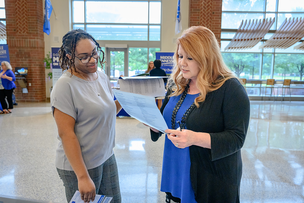 Jalyn Donaldson, left, who works in Middle Tennessee State University's Office of Admission in the area of student  recruitment, talks with Sherry Fuller, office coordinator in the College of Graduate Studies about a course of action for taking classes or pursuing a master's or doctorate degree. It was part of the four-hour "Don't Leave Money on the Table" event in the Student Union first-floor atrium, helping employees using a state and MTSU benefit to pay for the classes. (MTSU photo by J. Intintoli)