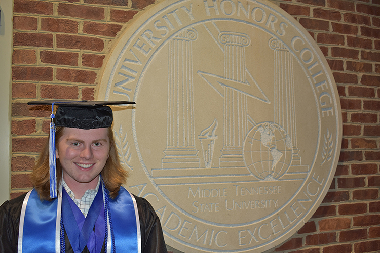 Posing here in his academic regalia in front of the Honors College seal at the Honors Building on the Middle Tennessee State University campus, spring 2023 graduate Benjamin Adams of Murfreesboro, Tenn., recently completed the Intercollegiate Studies Institute’s 2023 Honors Conference in Annapolis, Maryland. (Submitted photo)