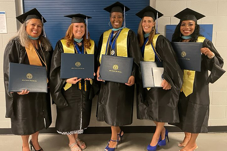 Recent graduates of Middle Tennessee State University and members of the “Grow Your Own” grant cohort, educational assistants who received funding from the Tennessee Department of Education to became licensed special education teachers, pose with their new Master of Education degrees on graduation day Aug. 12, 2023, at the Murphy Center on campus. Pictured, from left, are Ruth Gonzalez-Hill, Bre Clark, Nichelle Shelton, Brittany Jackson and Ariel Davie. (Submitted photo)
