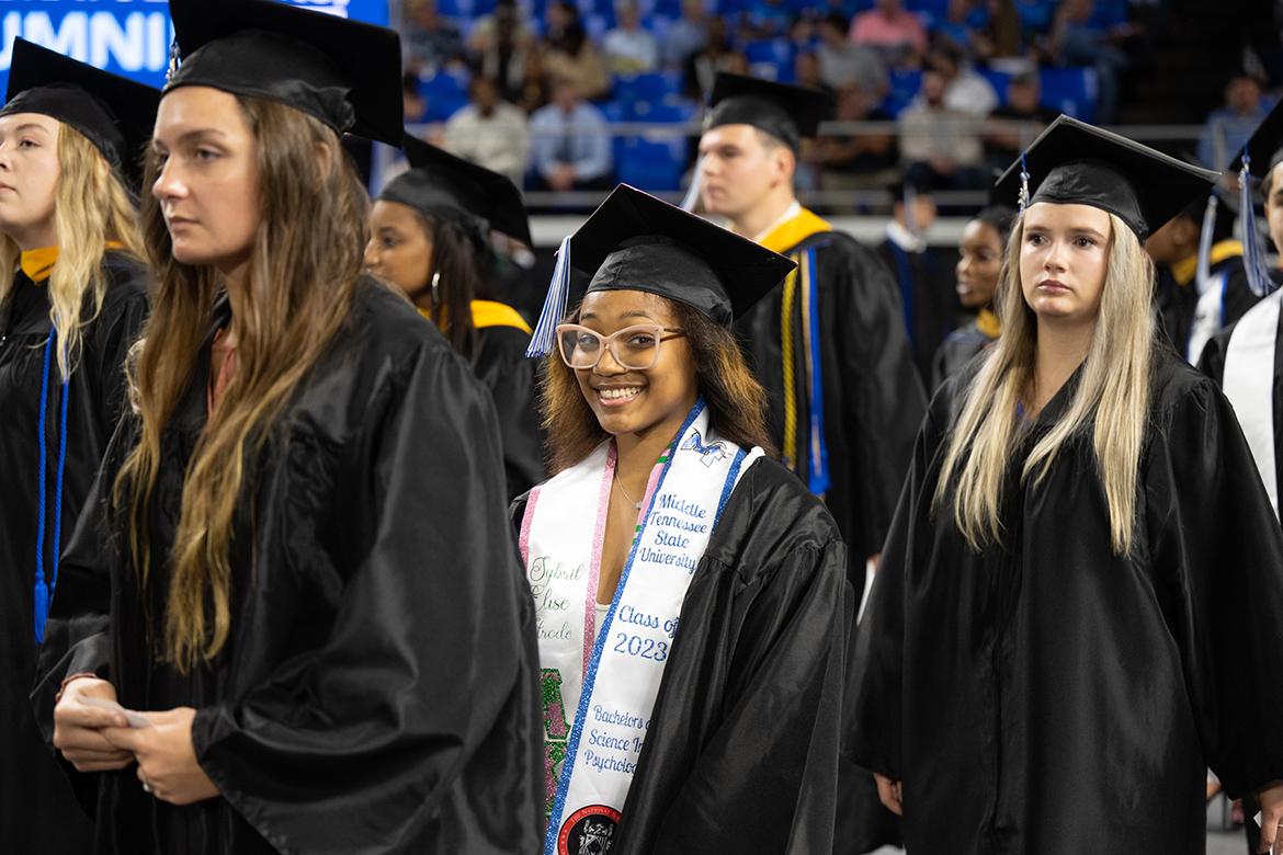 Middle Tennessee State University graduate and Alpha Kappa Alpha sorority member Sybril Strode, center, is all smiles as she prepares to receive her psychology degree during the summer 2023 commencement ceremony held inside Murphy Center on the MTSU campus in Murfreesboro, Tenn. (MTSU photo by James Cessna)