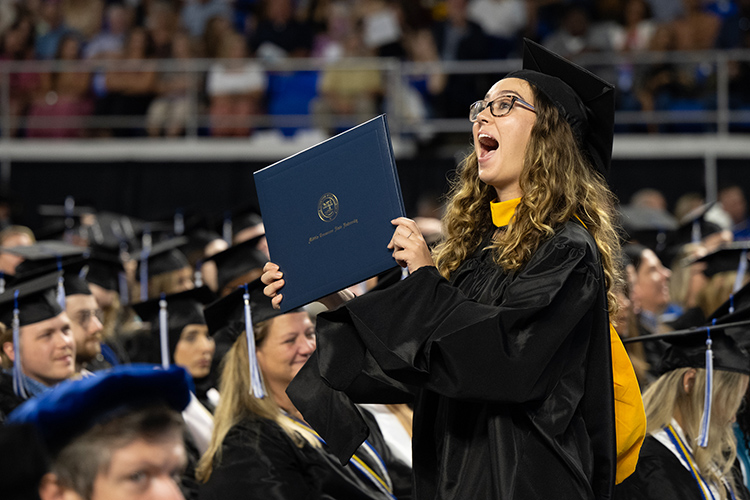 A Middle Tennessee State University graduate proudly holds up her diploma cover during the summer 2023 commencement ceremony held inside Murphy Center on the MTSU campus in Murfreesboro, Tenn. (MTSU photo by James Cessna)