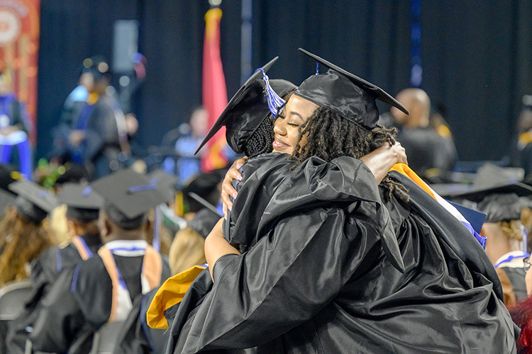 Two proud Middle Tennessee State University graduates embrace during the summer 2023 commencement ceremony held inside Murphy Center on the MTSU campus in Murfreesboro, Tenn. (MTSU photo by J. Intintoli)