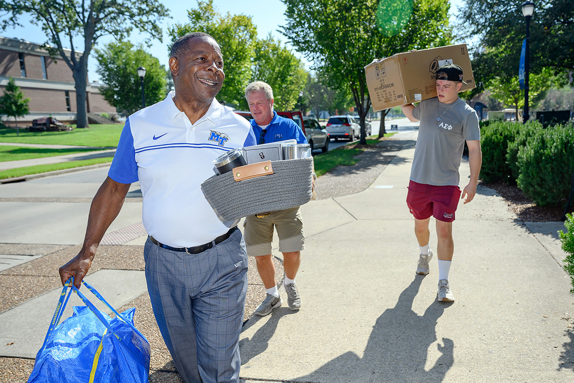 Middle Tennessee State University President Sidney A. McPhee, left, assists parent Joe Kirk and Hunter Rogers, a new freshman attending MTSU this fall, with the move-in to campus Wednesday, Aug. 23, outside Corlew Hall on MTSU Boulevard. About 2,700 new and returning students will be staying in campus housing this fall. (MTSU photo by J. Intintoli)