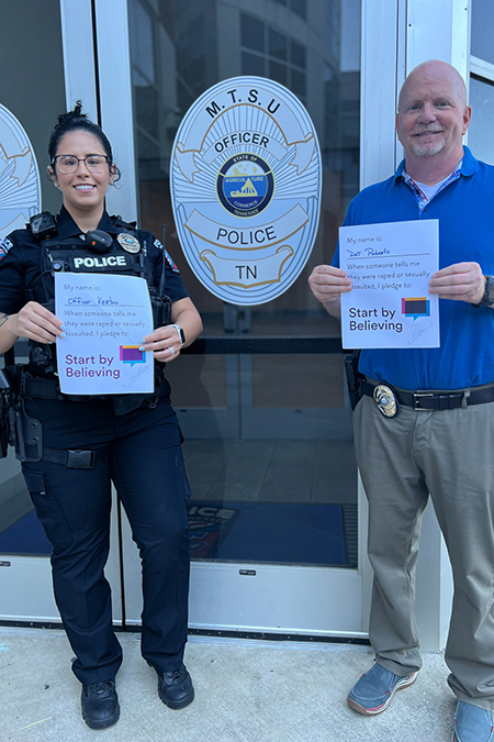 Middle Tennessee State University Police Detective Tommy Roberts, who specializes in investigating domestic violence and sexual assault, and officer Hope Kerbo hold up their signed “Start by Believing” pledge forms in December 2022, part of the Sexual Violence Prevention Tool Kit put together by the university’s June Anderson Center for Women and Nontraditional Students. (Submitted photo)