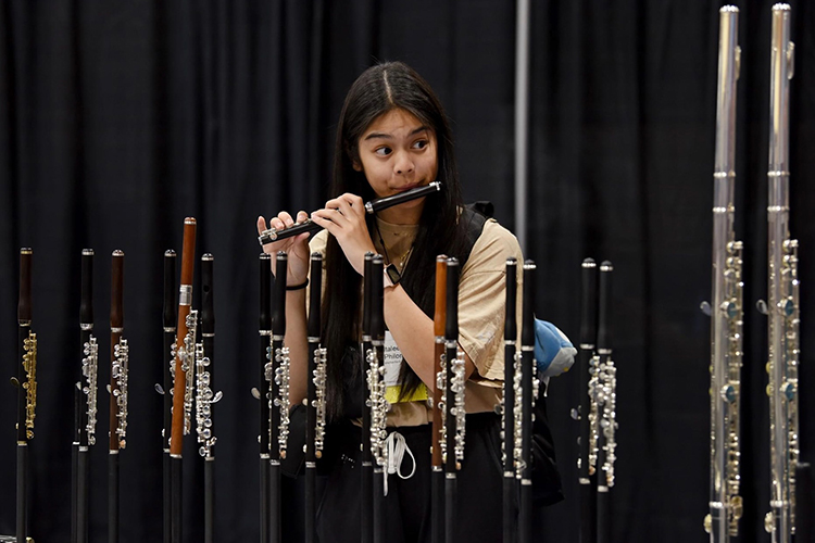 Italee Philom, Middle Tennessee State University student and flute performance major, tries out piccolos in the Phoenix Convention Center Exhibit Hall in Phoenix, Arizona, on Aug. 6, 2023. Philom recently attended the prestigious National Flute Association Convention in Phoenix, along with seven other MTSU students. (Submitted photo)