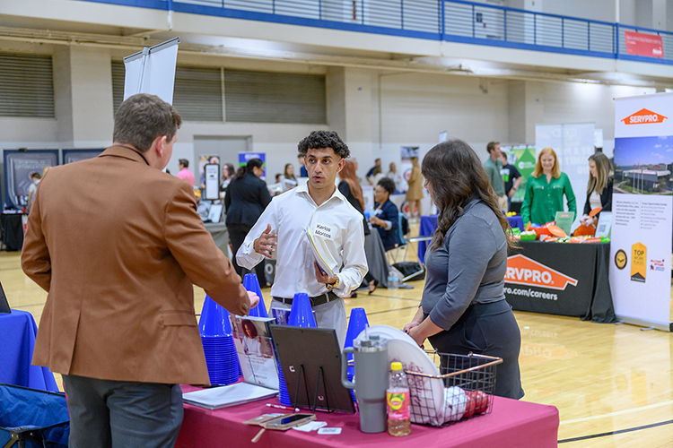 Wilson Bank representatives Jaimie Hutchins, left, and Leslie Pionke, right, speak Thursday, Sept. 28, with Middle Tennessee State University Fall Career Fair attendee Kerlos Morcos. Representatives from almost 180 employers networked with the 1,000-plus students and alumni at the event held inside the Campus Recreation Center and hosted by the MTSU Career Development Center. (MTSU photo by J. Intintoli)