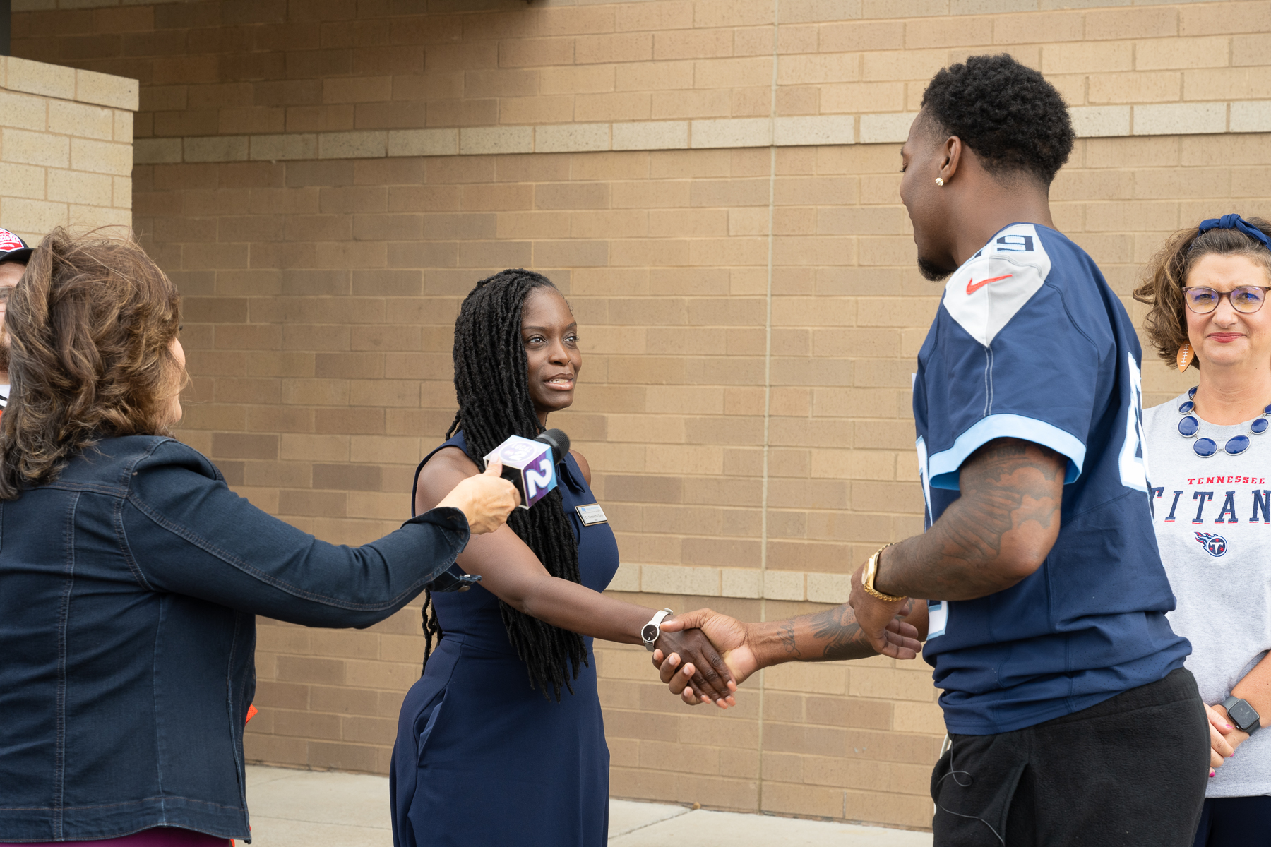 Middle Tennessee State University College of Education Dean Neporcha Cone greets Tennessee Titans player Arden Key recently as part of WKRN-TV News 2's "Take a Titan 2 School" series at Smith Springs Elementary School in Antioch, Tenn. (MTSU photo by James Cessna) 