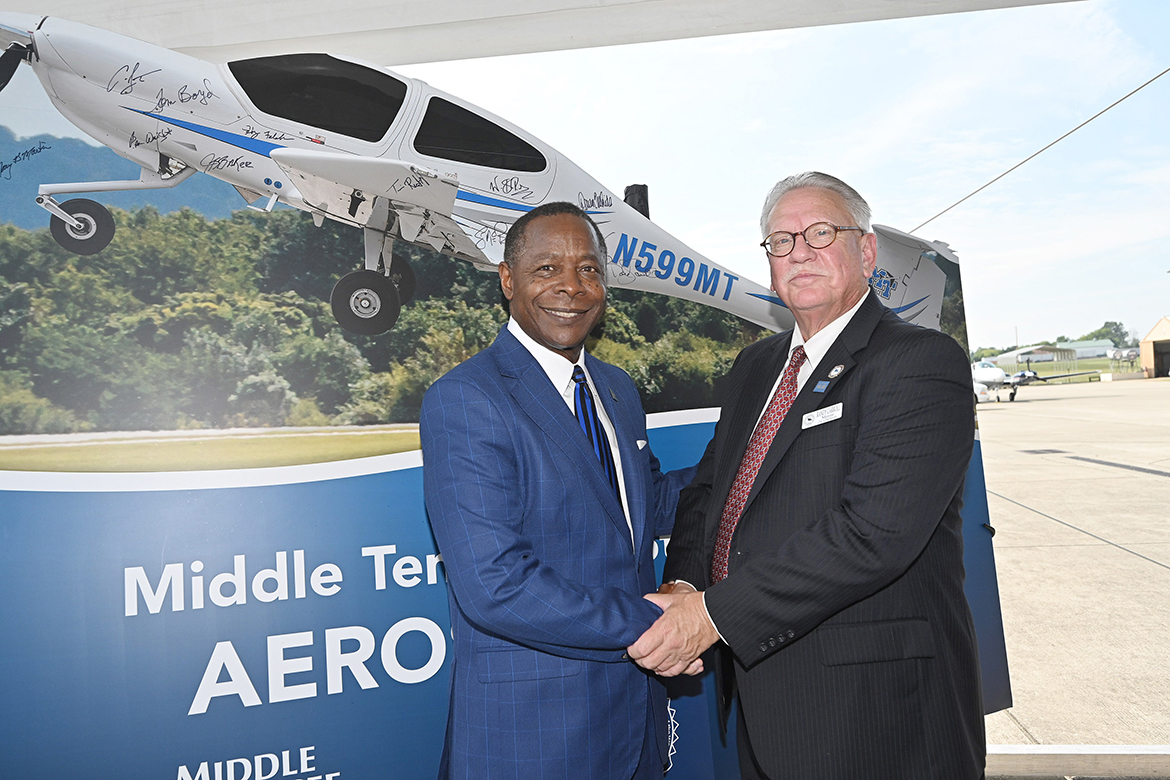 Middle Tennessee State University President Sidney A. McPhee, left, shakes hands with Shelbyville, Tenn., Mayor Randy Carroll Thursday, Sept. 21, after signing the promotional sign as part of the announcement of the MTSU Aerospace Department eventual move to Shelbyville Municipal Airport. (MTSU photo by J. Intintoli)