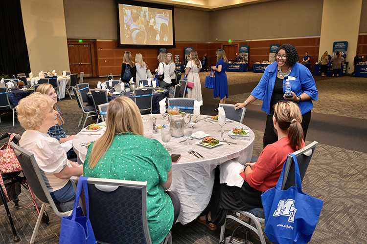 Leah Lyons, standing right, dean of the College of Liberal Arts at Middle Tennessee State University greets a table of Rutherford County counselors attending a True Blue Tour kickoff appreciation luncheon Sept. 13 in the university’s Student Union Ballroom. The True Blue Tour is an annual 14-city tour featuring counselor luncheons and evening student/parent receptions to recruit prospective students led by McPhee, top administrators, admissions staff and advisors. (MTSU photo by Andy Heidt)
