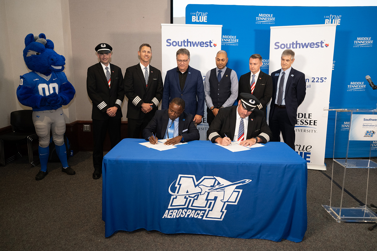Middle Tennessee State University President Sidney A. McPhee, left, and Southwest Airlines Capt. Brad Monda sign documents formalizing the partnership as MTSU enters the airline’s Destination 225° program Wednesday, Sept. 6, in the Business and Aerospace Building’s State Farm Lecture Hall. Back row, from left, are MTSU mascot Lightning, Southwest Capt. Sean Strittmatter (program recruitment lead), Southwest Capt. Justin Peele (recruitment program manager), MTSU Provost Mark Byrnes and Aerospace Chair Chaminda Prelis, Southwest First Officer Chris Collins (program lead mentor and MTSU alumnus) and College of Basic and Applied Sciences Dean Greg Van Patten. (MTSU photo by James Cessna)