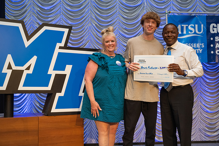 Preston Kropczynski, center, and his mom, Dedra Schulz, left, take the stage with Middle Tennessee State University President Sidney A. McPhee after McPhee drew Kropczynski’s name for a $5,000 scholarship during the university’s kickoff event Wednesday, Sept. 13, 2023, for the True Blue Tour, a recruitment event for prospective MTSU students, at the Student Union Building on campus in Murfreesboro, Tenn. (MTSU photo by Cat Curtis Murphy)