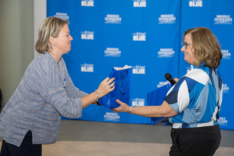 Jennifer Hyde, right, executive assistant of Middle Tennessee State University’s Assessment, Learning and Student Success doctoral program, hands out a gift to Leslie Trail, an attendee, at the program’s 10-year celebration event on Sept. 16, 2023, at the Miller Education Center in Murfreesboro, Tenn. (MTSU photo by James Cessna)