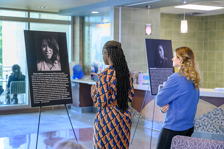Neporcha Cone, dean of the College of Education at Middle Tennessee State University, left, and another attendee walk the gallery of portraits at the “Humans of Murfreesboro” event on Sept. 26, 2023, at the education building on campus. The event, part of the university’s larger MT Engage Week of events, honored 11 local service professionals, such as teachers and police officers, by allowing them to share their human stories with attendees. (MTSU photo by James Cessna)