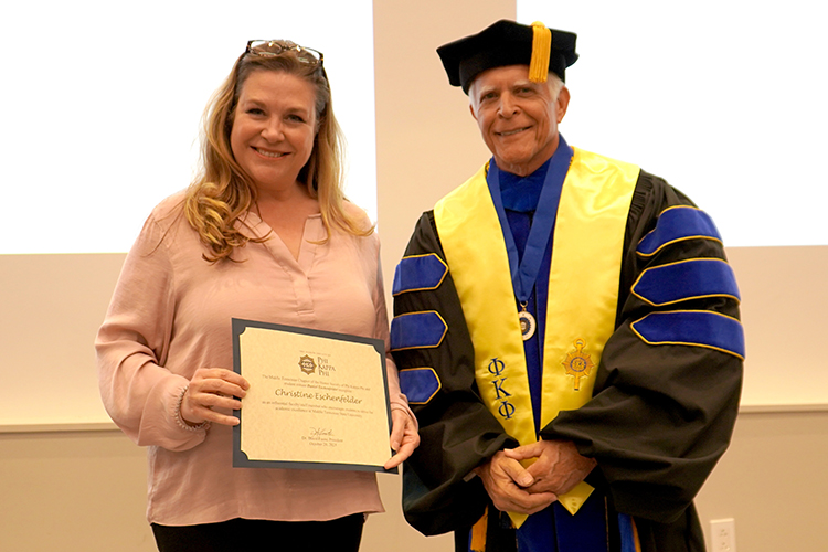 Middle Tennessee State University associate journalism professor Christine Eschenfelder, left, receives her Phi Kappa Phi faculty initiation certificate from David Foote, Chapter 246 of Phi Kappa Phi president and a management professor in the Jones College of Business, at the Phi Kappa Phi fall induction ceremony on campus Oct. 20, 2023. (MTSU photo by Robin E. Lee)